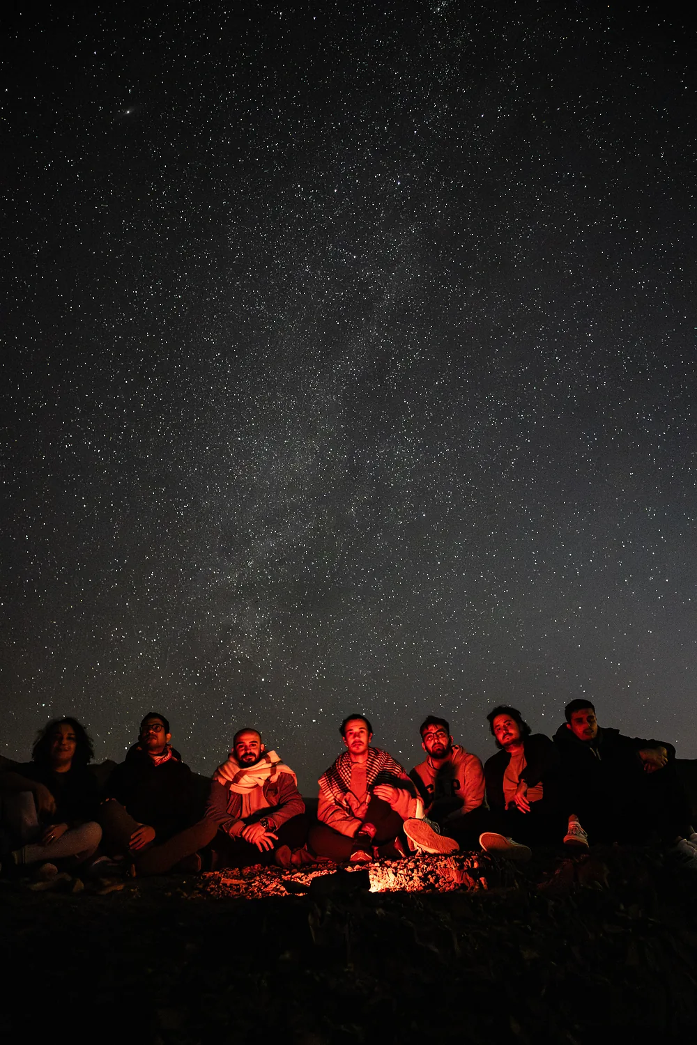Group around a campfire under the Milky Way