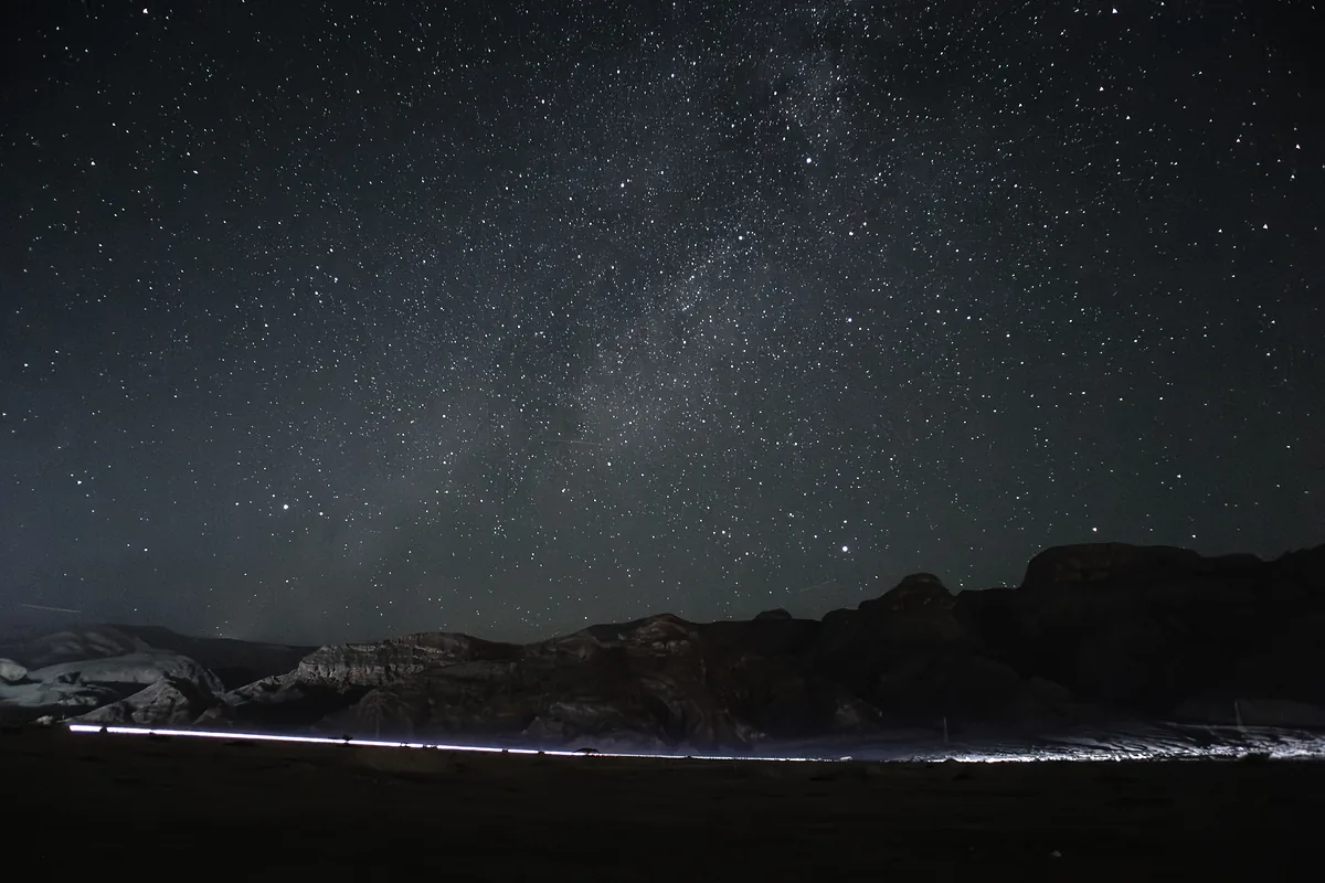 Milky Way with a car light trail across the frame