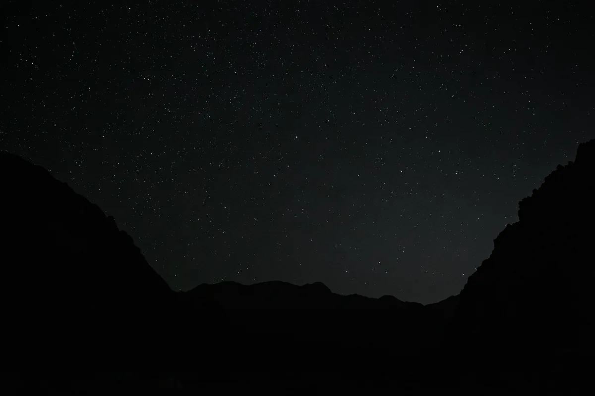 Dark valley silhouette under a star-filled sky